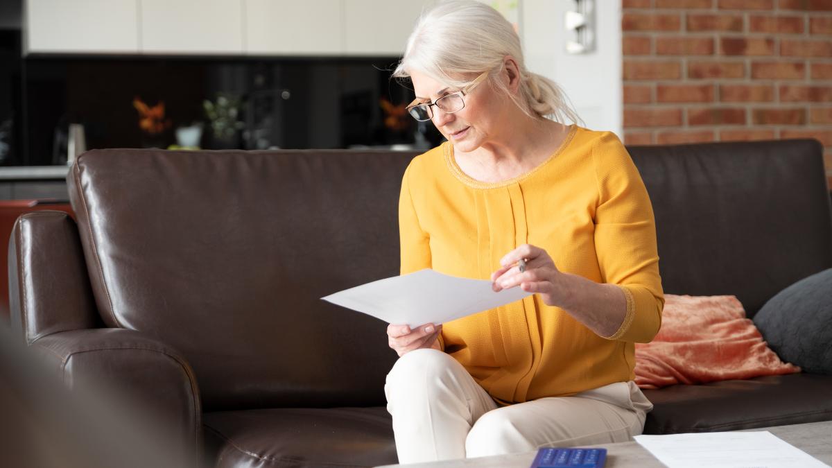 A professional woman reviewing documents on her laptop while preparing job references.