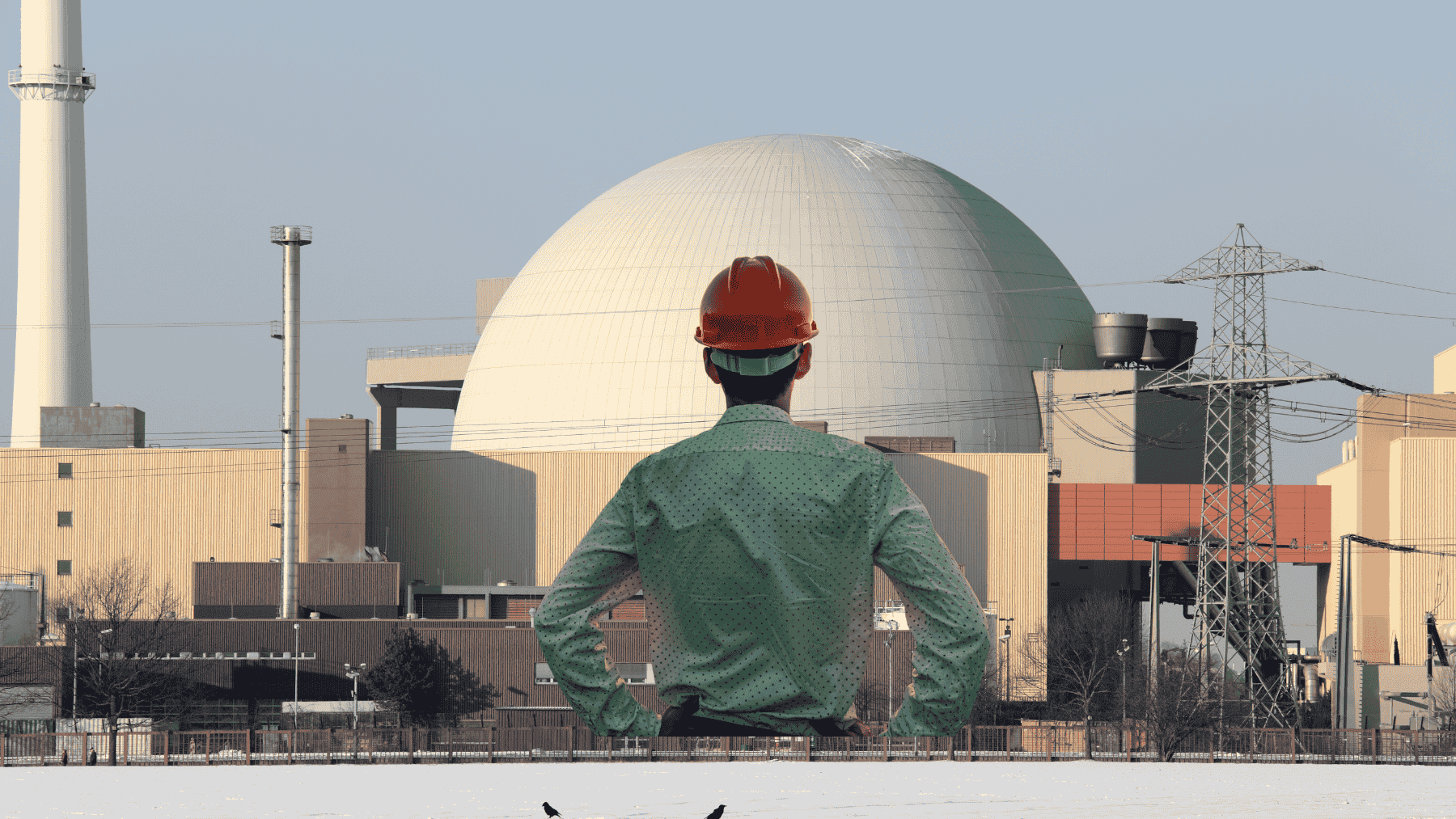 Canadian nuclear power plant with dome reactor and engineer in foreground, representing nuclear workforce and energy infrastructure in Canada
